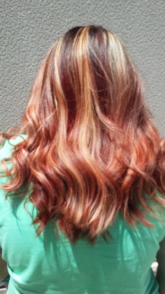 Long copper and blonde highlighted hair, softly waved