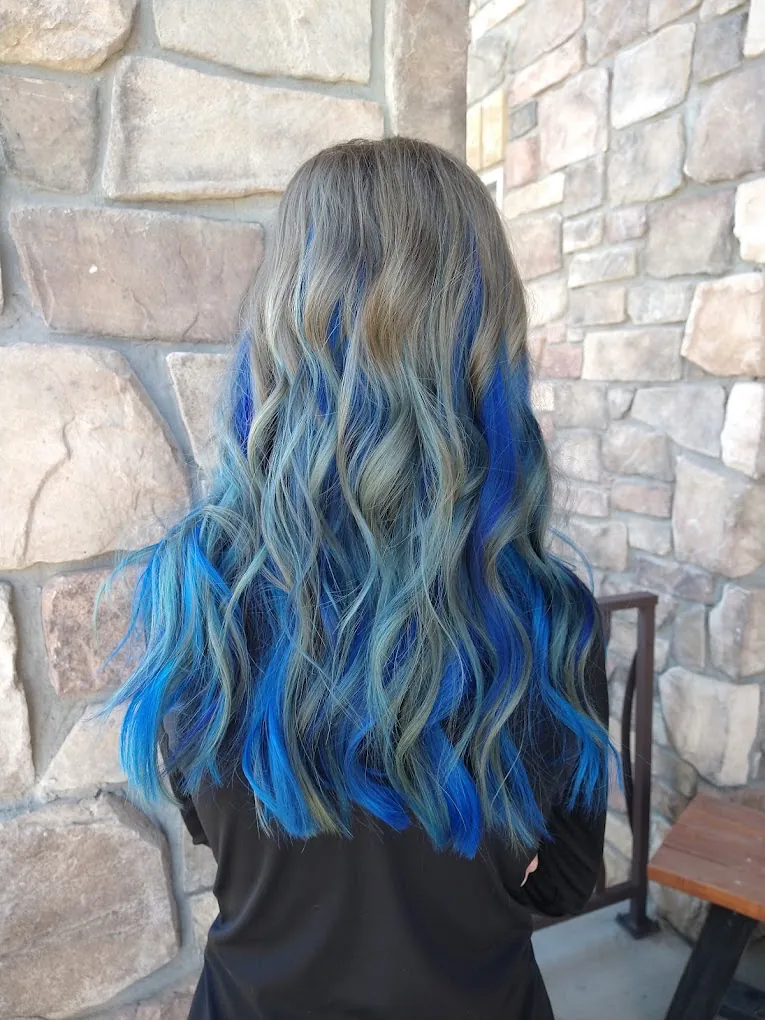 Sandy blonde hair with sapphire and teal vivid panels curled into waves